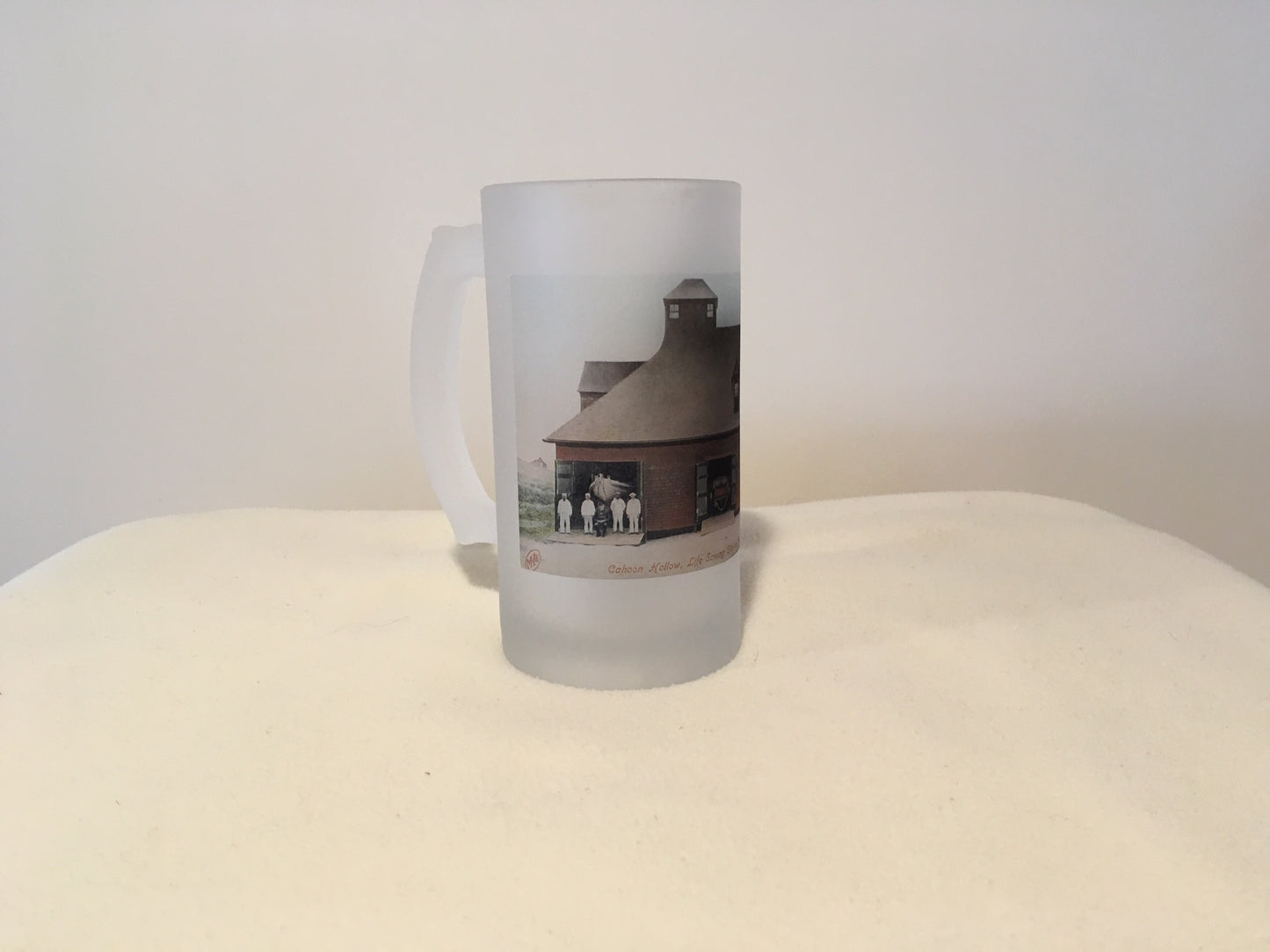 Frosted glass mug with a printed design on a white surface