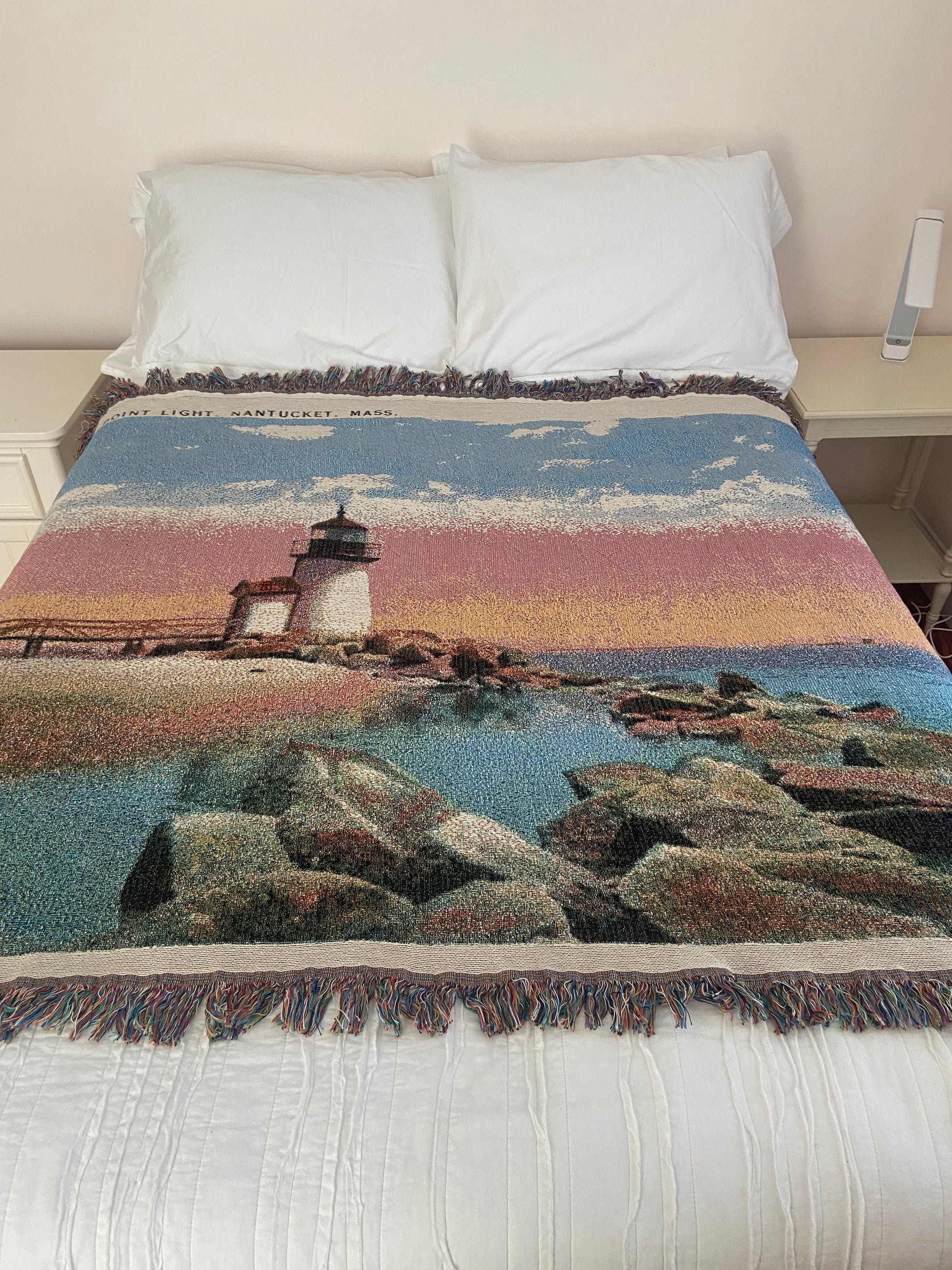 Textile with landscape design draped over a bed