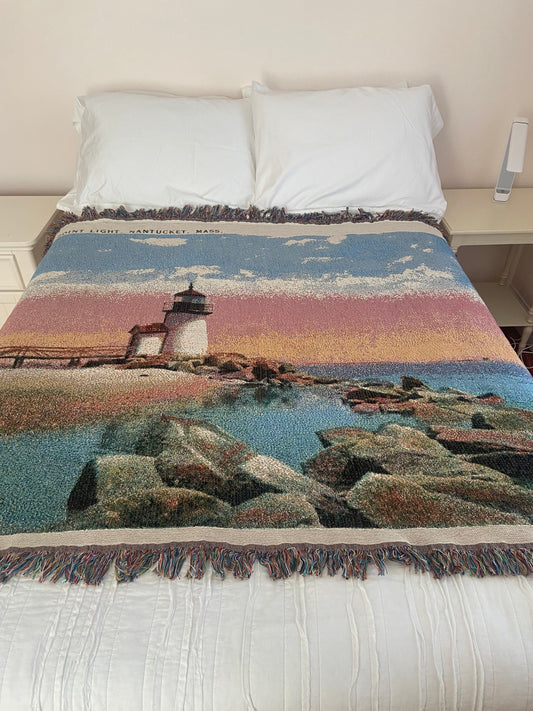 Textile with landscape design draped over a bed