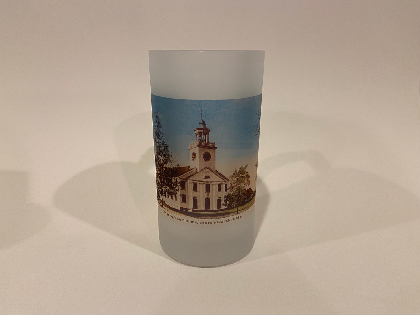 Frosted glass tumbler with a printed design of a church on a plain background